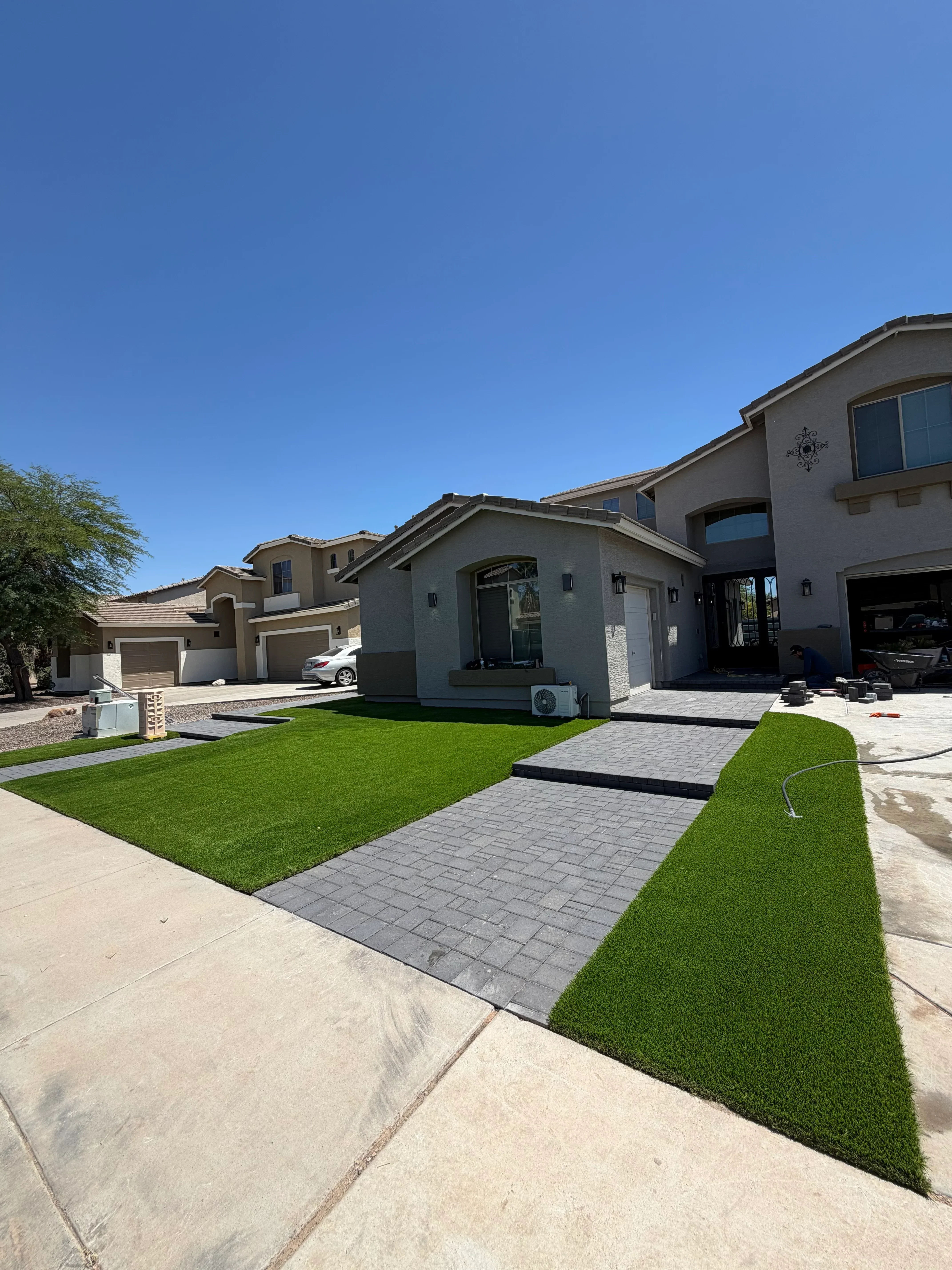 Newly installed green sod lawn with white vinyl privacy fence and concrete patio