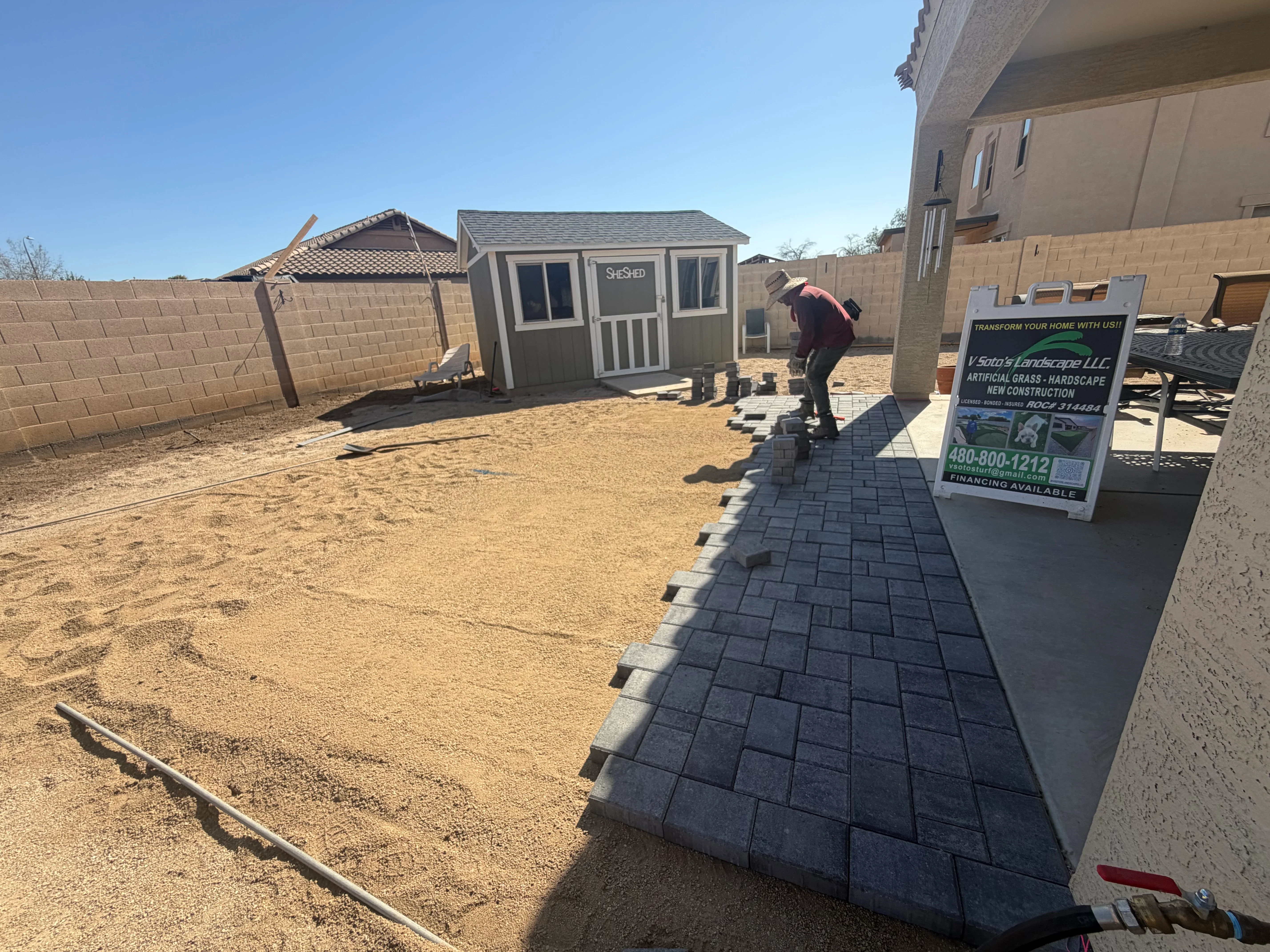 Dark gray paver patio installation with proper edging and base preparation in residential backyard