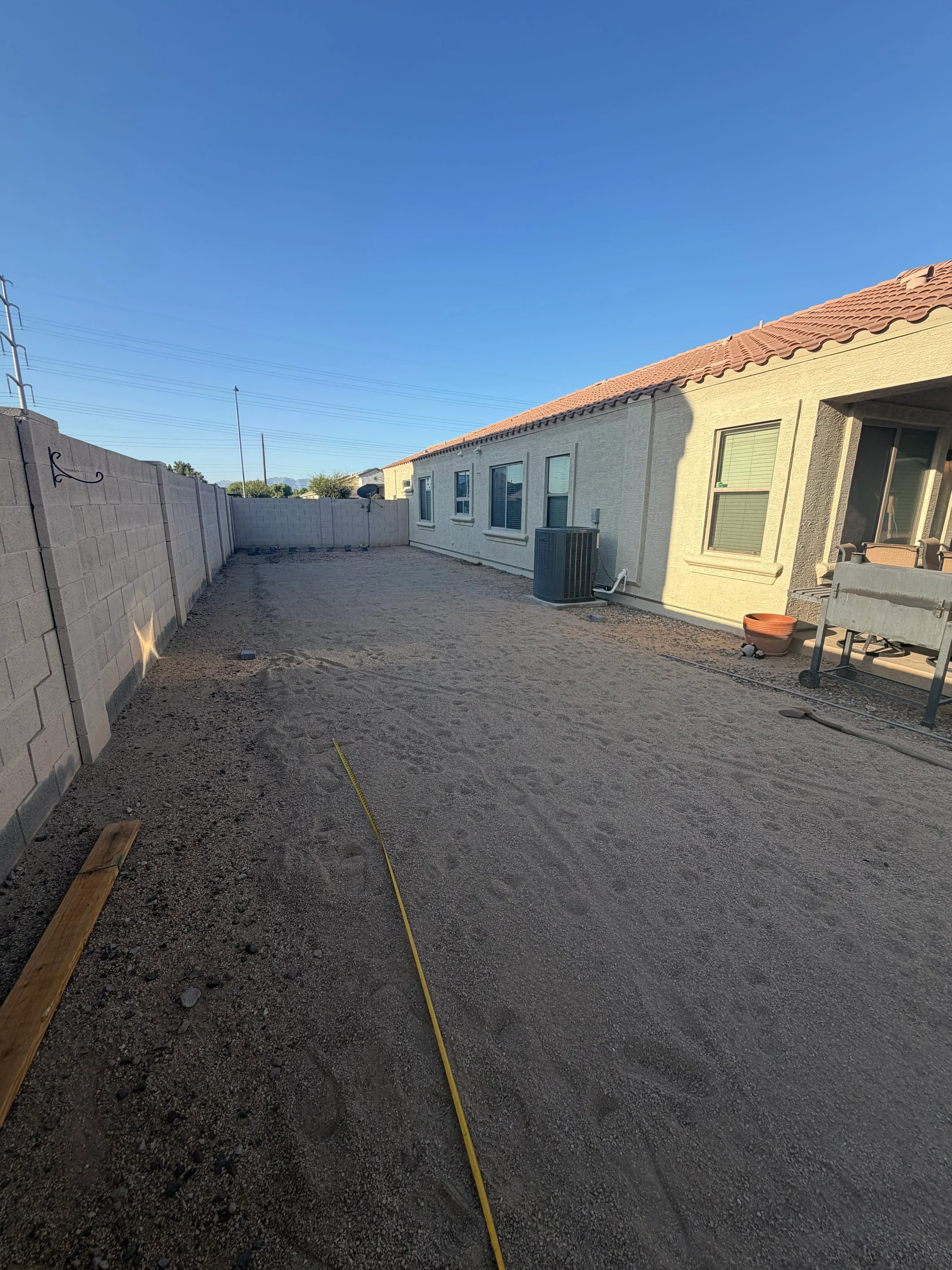 Paver driveway installation with brick home and concrete edging along residential property